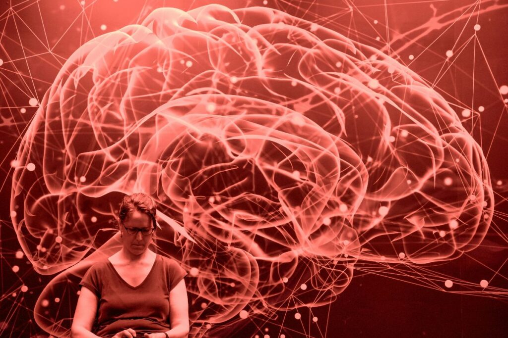 A person sitting reflectively, illustrating the internal struggle of figuring out if they are experiencing anxiety or ocd.